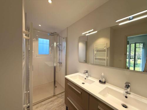 une salle de bain avec un lavabo, une douche et un miroir dans l'établissement Villa rénovée avec jardin à Petit-Piquey - Proche Bassin et Océan, 3 chambres, 2 terrasses, Wi-Fi - FR-1-736-4, à Lège-Cap-Ferret