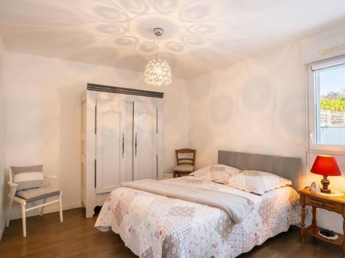 une chambre avec un lit et un lustre dans l'établissement Carnac : Appartement T2 de standing, 49m², proche marché, plage et Thalasso, Parking Inclus - FR-1-477-243, à Carnac