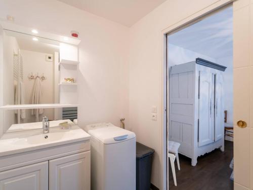 une salle de bain blanche avec un lavabo et un miroir dans l'établissement Carnac : Appartement T2 de standing, 49m², proche marché, plage et Thalasso, Parking Inclus - FR-1-477-243, à Carnac