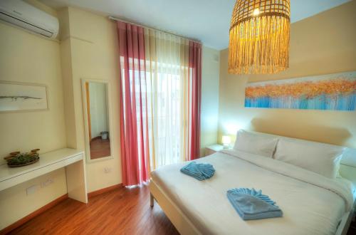 a bedroom with a large bed and a chandelier at Spacious & elegant 2 bedrooms, 2 bathrooms DBOR1-1 in Pieta