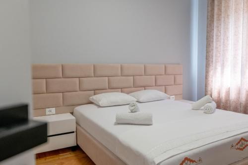 a bedroom with a large white bed with two pillows at Huna Apartment in Sarandë