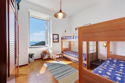 Un dormitorio con dos literas y una ventana. en Bilo Costella, en Bonassola
