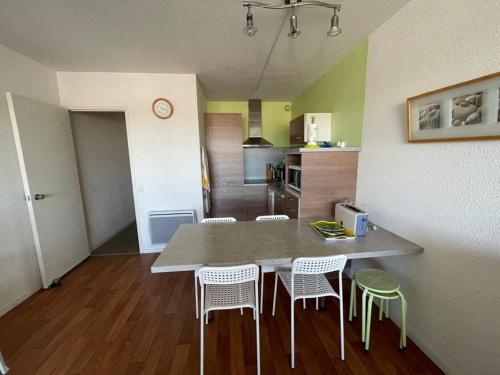 une cuisine et une salle à manger avec une table et des chaises dans l'établissement Appartement cosy 4 pers avec piscine et parking à Capbreton - FR-1-413-256, à Capbreton