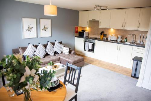 a living room and kitchen with a couch and a table at Laburnum Cottages - Stratford upon Avon in Stratford-upon-Avon