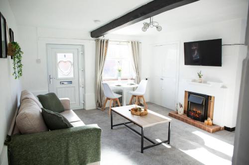 a living room with a couch and a fireplace at Laburnum Cottages - Stratford upon Avon in Stratford-upon-Avon
