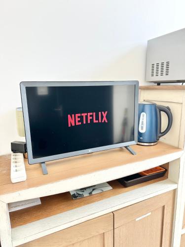 - une télévision à écran plat installée au-dessus d'un centre de divertissement dans l'établissement Le Francis, petit studio proche métro A, à Villeurbanne