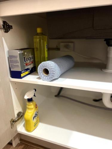 a shelf with a roll of toilet paper and detergent at Amukta nook in Truganina