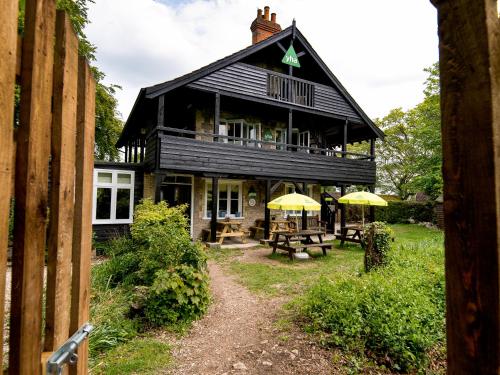 a large black house with yellow umbrellas in front of it at YHA Street in Street
