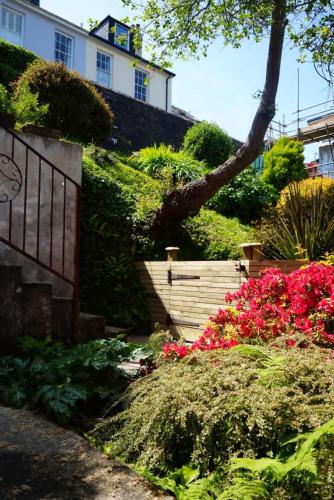 a garden with pink flowers in front of a building at Fabulous High Street Townhouse With Stunning Views & Parking at 'Eagles Nest' in Falmouth