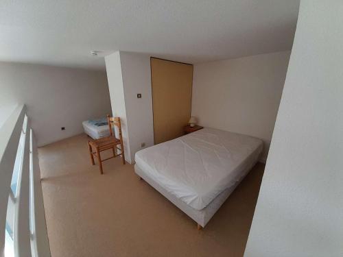 une petite chambre avec un lit et une chaise dans l'établissement Appartement T2 mezzanine proche mer à St Hilaire de Riez - FR-1-324-149, à Saint-Hilaire-de-Riez