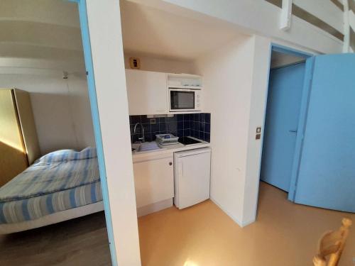 Cette petite chambre comprend une cuisine et un lit. dans l'établissement Appartement T2 mezzanine proche mer à St Hilaire de Riez - FR-1-324-149, à Saint-Hilaire-de-Riez