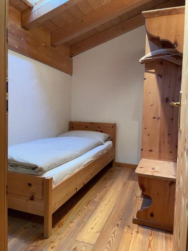 a bedroom with a bed and a wooden floor at Residence Miragolf in Madulain