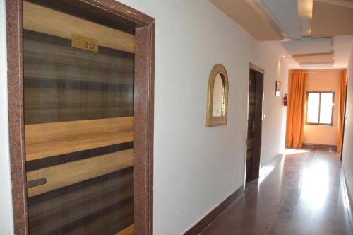 a hallway with a sliding door with wood paneling at Tak International Hotel in Udaipur