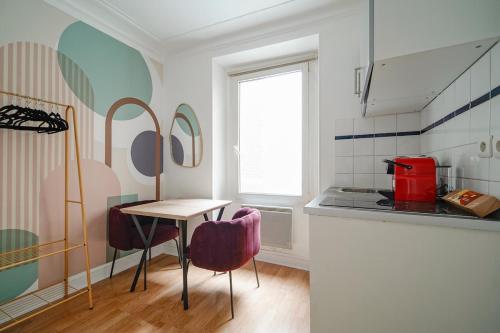 une cuisine avec une table et des chaises dans une pièce dans l'établissement Cozy studio in Voltaire - V, à Paris