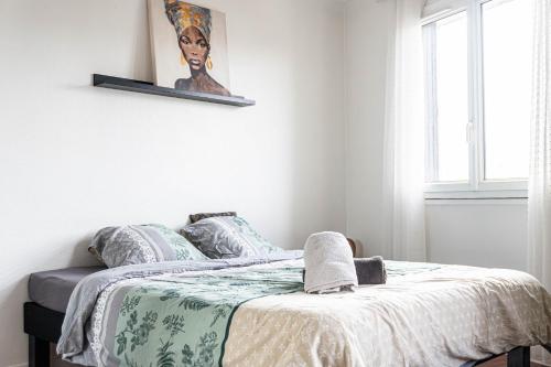 une chambre avec un lit avec une couverture dessus dans l'établissement Appartement cosy & lumineux près de Paris, à Fresnes