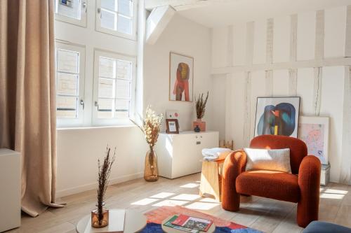 un salon avec une chaise et une table dans l'établissement Le Loft Brunneval - Refuge Arty du XVIe siècle, à Troyes