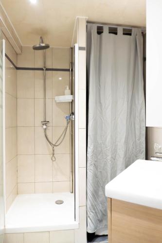 une douche avec une porte vitrée dans une salle de bain dans l'établissement Appartement cosy & lumineux près de Paris, à Fresnes