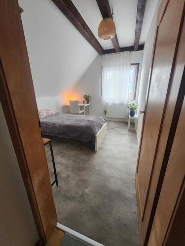 une chambre avec un lit et une table dans une pièce dans l'établissement MIN HISELE, Ma PETITE MAISON, à Lingolsheim