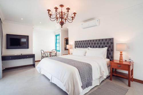 a bedroom with a large bed and a tv at Villa dos Poetas in Barra Grande
