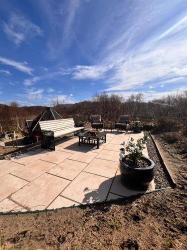 un patio in pietra con panca e panca di Glenwood glamping pod a Morar