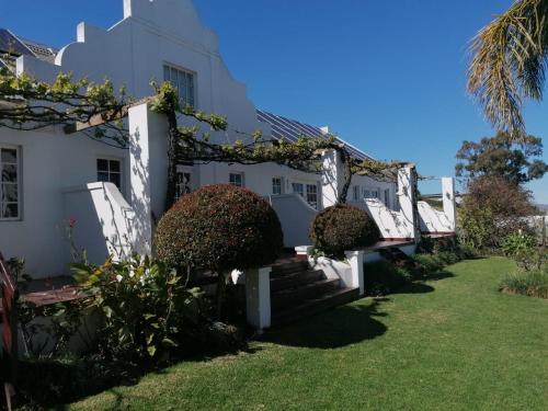 a white house with stairs and plants at theLAB Robertson in Robertson