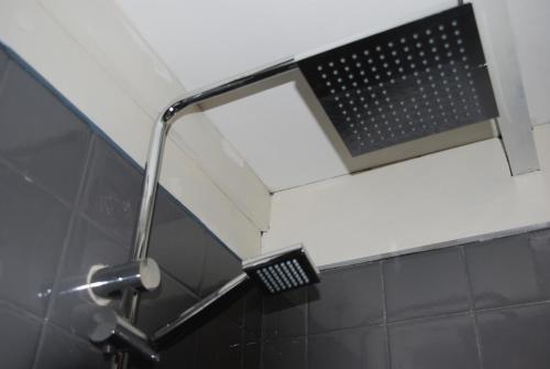 einen Duschkopf im Bad mit Spiegel in der Unterkunft B&B De Hagmolenbeek Boekelo in Boekelo