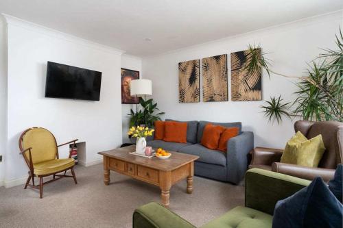 a living room with a couch and a table at Peaceful & Tranquil Cottage With Private Terrace at 'The Pink House' in Falmouth