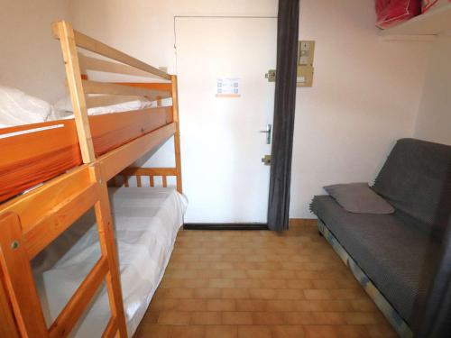 Cette petite chambre comprend des lits superposés et une porte menant à un placard. dans l'établissement Studio Climatisé Double Cabine avec Piscine et Parking à 650m de la Plage - FR-1-307-140, au Grau-du-Roi