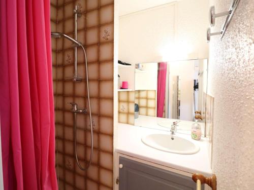 La salle de bains est pourvue d'un lavabo et d'un rideau de douche rouge. dans l'établissement Studio Climatisé Double Cabine avec Piscine et Parking à 650m de la Plage - FR-1-307-140, au Grau-du-Roi