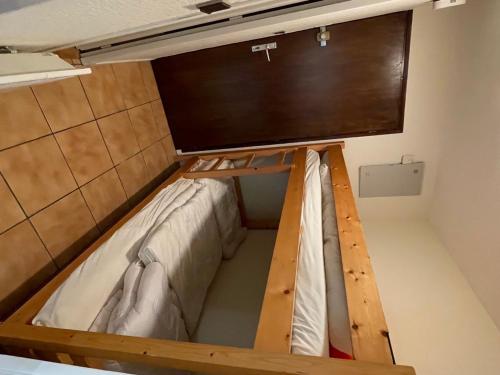 Ce lit se trouve dans un dortoir doté d'une télévision murale. dans l'établissement Studio calme à Samoëns avec terrasse, parking et coin cuisine - FR-1-629-30, à Samoëns