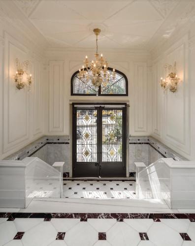 a white room with a chandelier and a large door at Atik Suite Taksim in Istanbul