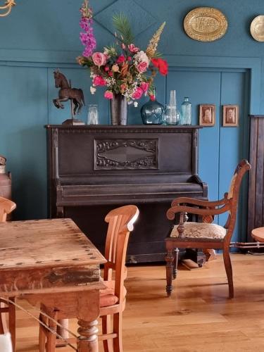 a dining room with a table and a piano at Hotel Zur Luppbode in Treseburg
