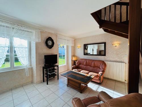 a living room with a couch and a tv at Maison située dans longère 6 à 8 personnes proche du bourg de Guidel - ALARIC in Guidel