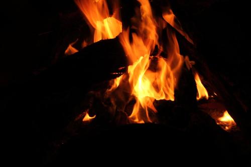 a fire burns in a fire pit at night at Erg Chigaga Wil Camp in El Gouera