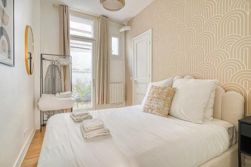 - une chambre avec un grand lit blanc et une chaise dans l'établissement Appartement équipé quartier Montparnasse - X, à Paris