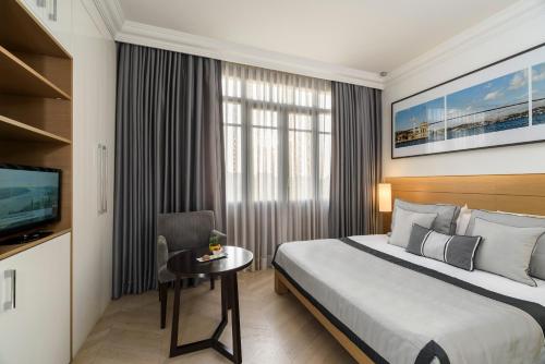 a hotel room with a bed and a table and a television at Atik Suite Taksim in Istanbul