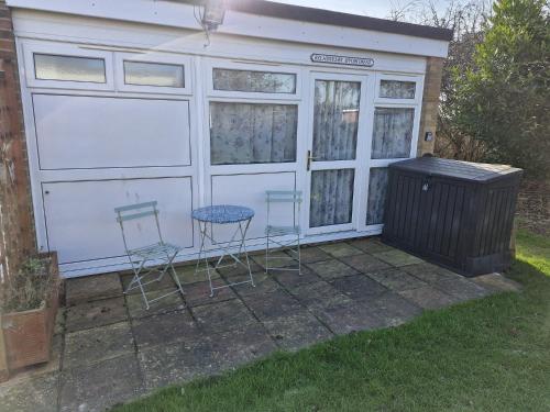 two chairs and a table in front of a garage at Parkview Retreat in Hemsby