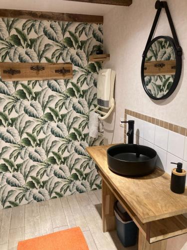 La salle de bains est pourvue d'un lavabo et d'un papier peint feuilleté. dans l'établissement La vieille Ferme, à Chorges