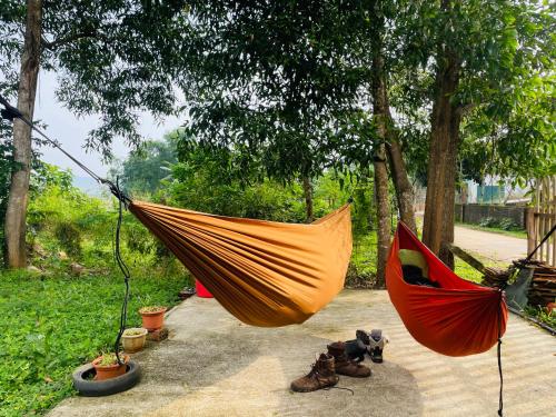 an orange hammock and a red umbrella on a patio at Hieu-Homestay in Phong Nha