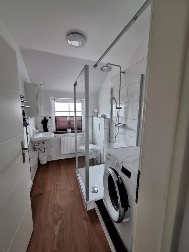 a bathroom with a washing machine and a sink at Ferienwohnungen Eisenbarth in Schneverdingen