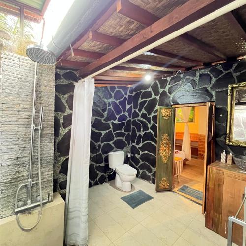 a bathroom with a shower and a toilet in a room at Yoga Maya Villa in Gianyar