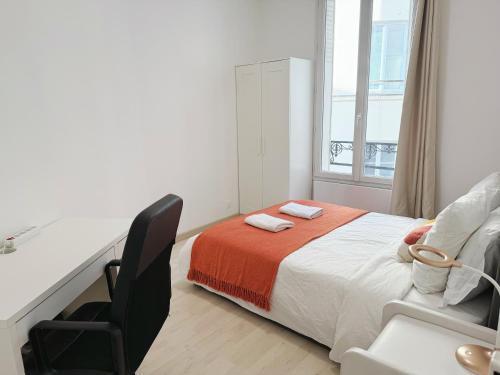 une chambre avec un lit, un bureau et une chaise dans l'établissement Le Magenta - Coeur de Paris - Canal Saint Martin - 3 Chambres 6 personnes, à Paris