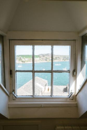 a window in a room with a view of the ocean at Breathtaking High Street Townhouse With Stunning Sea Views at 'The Old Fishermans Townhouse' in Falmouth