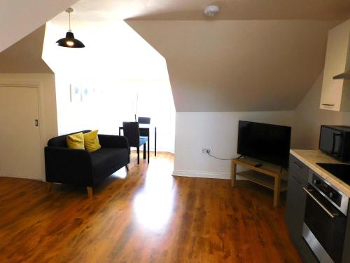 a living room with a couch and a tv at No 7 - Modern 1 Bedroom Apartment in Lanark Town Centre in Lanark