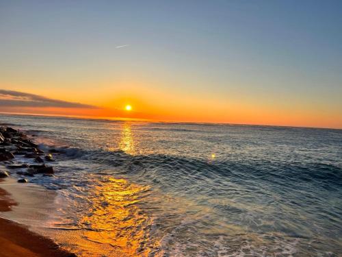 einen Sonnenuntergang am Strand mit Sonnenuntergang in der Unterkunft Camping Resort Els Pins in Malgrat de Mar