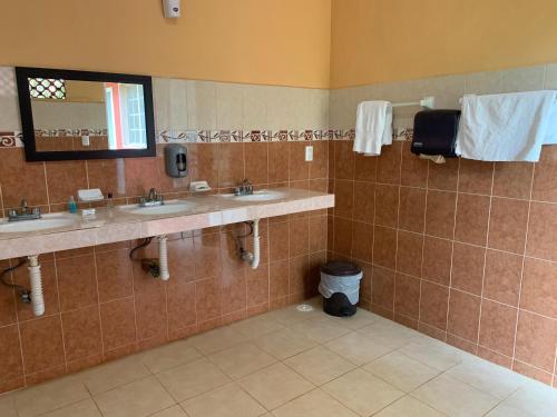 a bathroom with two sinks and a mirror at Quinta YaaxBe in Homún