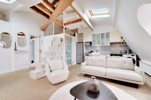 un salon avec un canapé et une table dans l'établissement Loft d'exception Courcelles - parc Monceau, à Paris