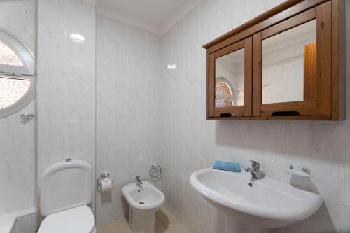 a white bathroom with a sink and a toilet at Tu Alojamiento En Playa Paraiso in Adeje