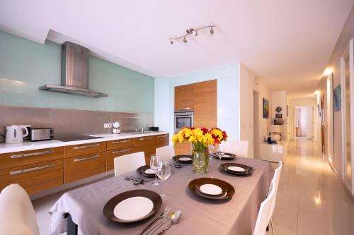 a kitchen with a table with flowers on it at Large & modern 3 bedrooms near Spinola Bay MMAI1-3 in St. Julianʼs
