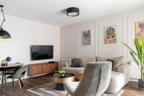 a living room with a couch and a tv at Scala City Center Premium Apartments with Parking by Lion Apartments in Gdańsk